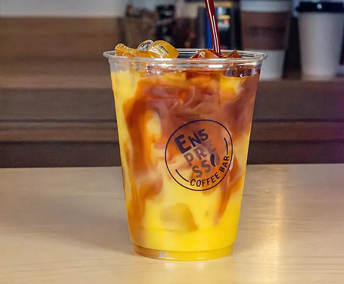 Espresso vertido sobre una bebida helada de naranja