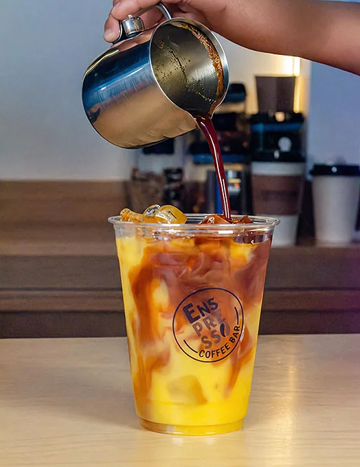 Espresso vertido sobre una bebida helada de naranja